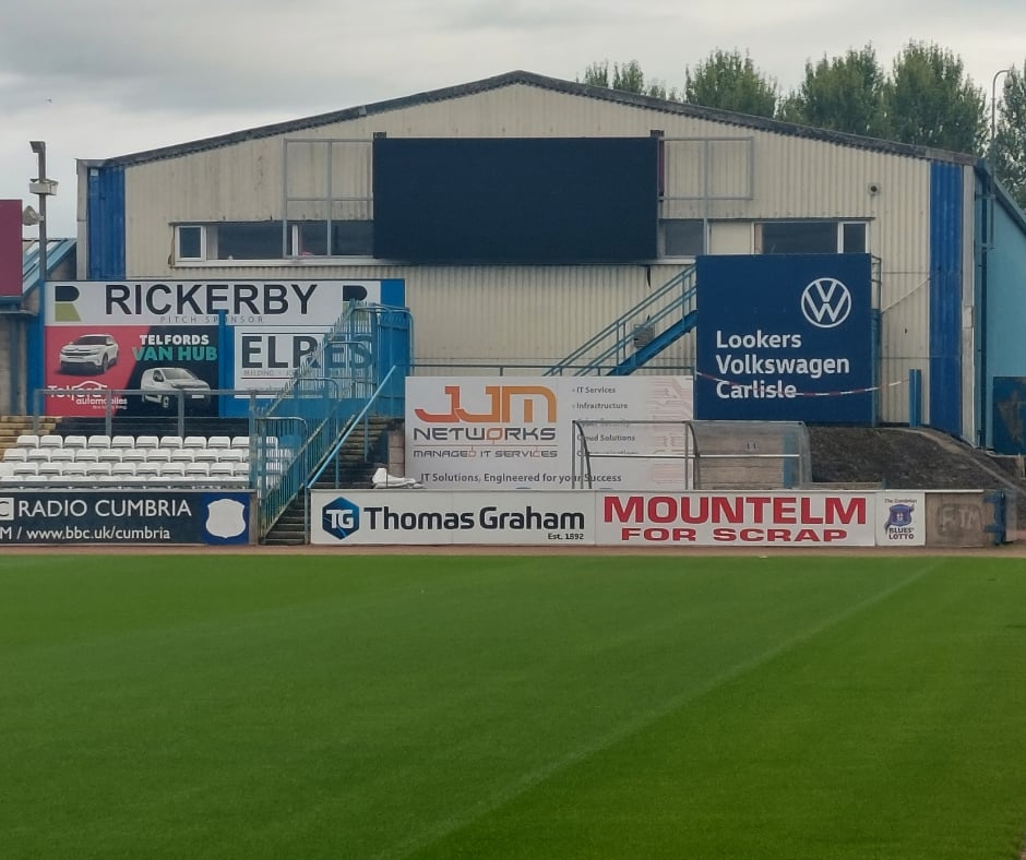 JJM Networks Carlisle United advertising partnership artwork at Brunton Park, marking another season of local sponsorship.