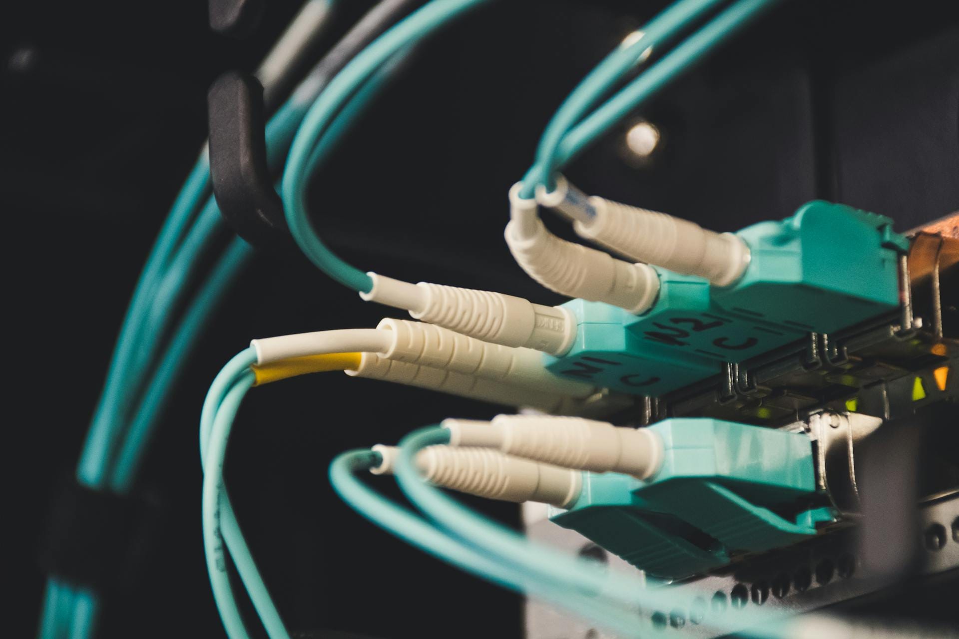 Fibre optic strands glowing into the distance, the kind of business broadband and leased line connectivity JJM Networks brokers for Carlisle and Cumbria