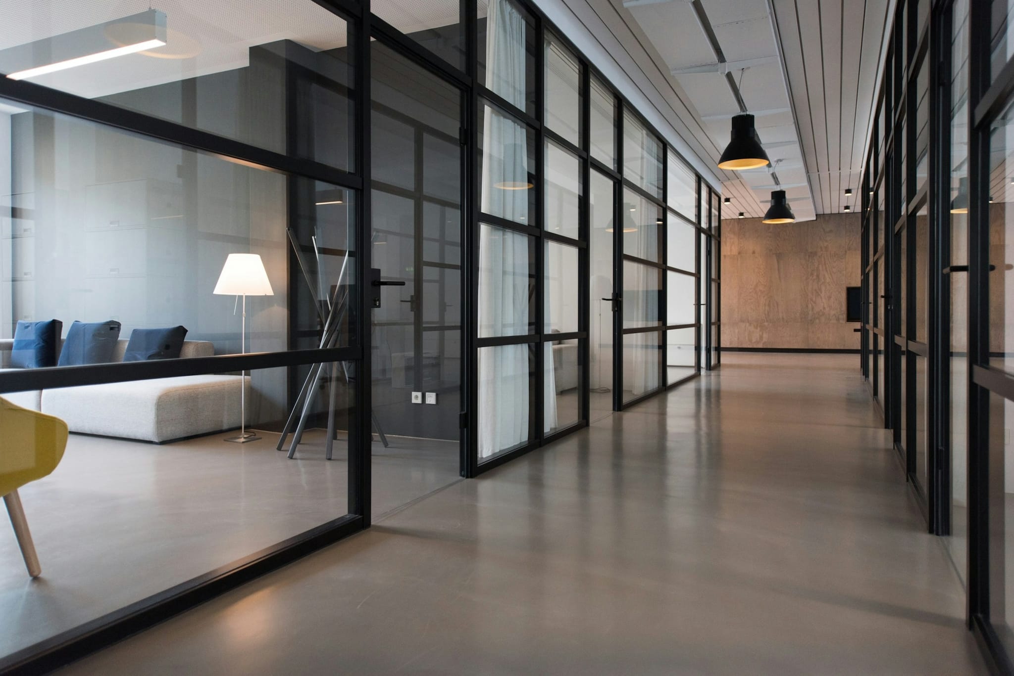 A modern open-plan office with glass-walled meeting rooms, the kind of space JJM Networks designs Ubiquiti UniFi business WiFi for across Cumbria